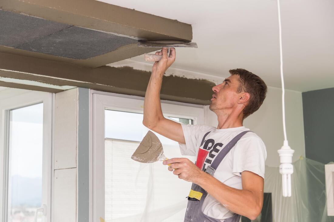 man in Fredericton repairing the ceiling of a home